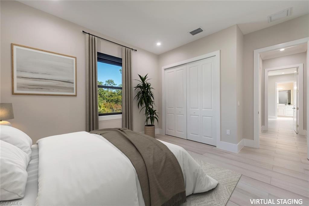 662 9th Street Southwest Naples, FL 34117 - Photo 24 of 34 a spacious bedroom with a bed and a painting on the wall