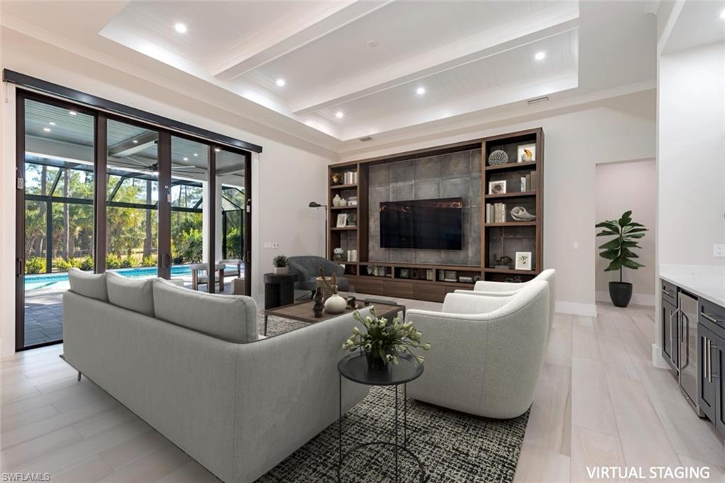 662 9th Street Southwest Naples, FL 34117 - Photo 3 of 34 a living room with furniture a flat screen tv and a large window