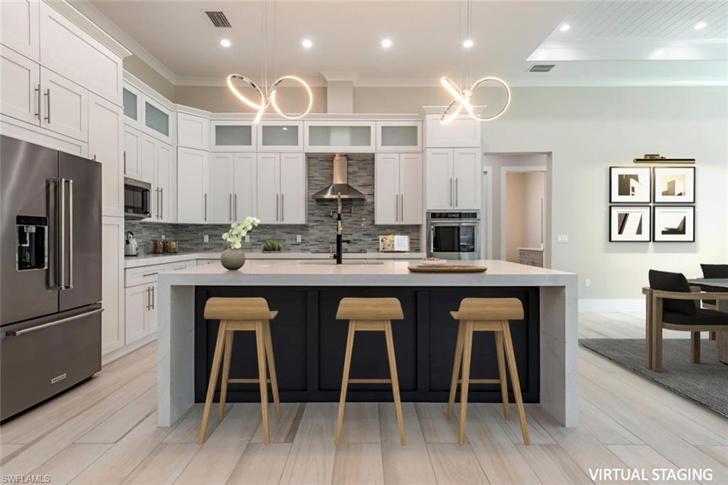 662 9th Street Southwest Naples, FL 34117 - Photo 5 of 34 a kitchen with stainless steel appliances granite countertop a kitchen island hardwood floor sink and stove