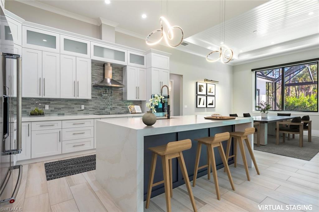 662 9th Street Southwest Naples, FL 34117 - Photo 6 of 34 a kitchen with a dining table chairs cabinets and stainless steel appliances