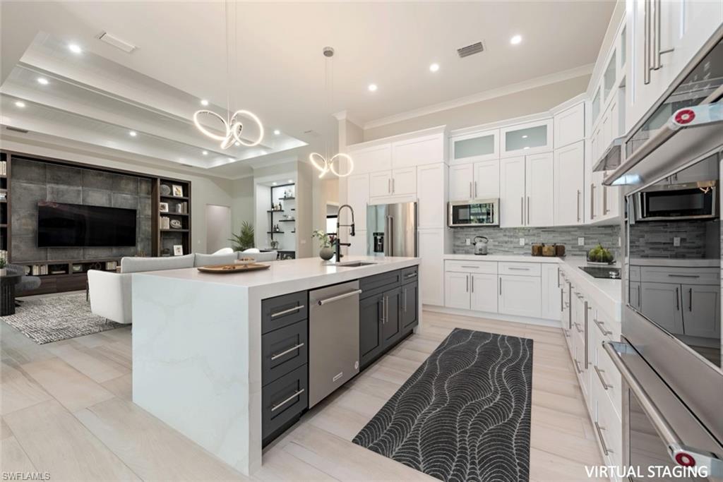 662 9th Street Southwest Naples, FL 34117 - Photo 7 of 34 a large kitchen with stainless steel appliances kitchen island granite countertop a stove a sink a microwave and a refrigerator