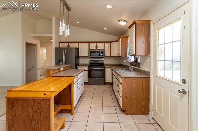 a kitchen with stainless steel appliances granite countertop a sink counter space cabinets and a large window