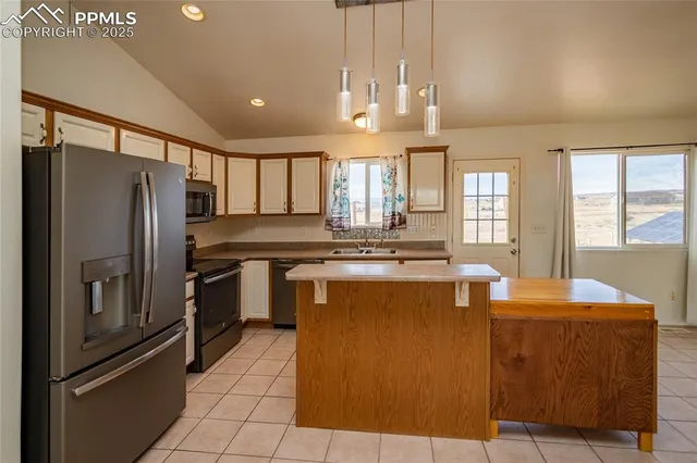 a kitchen with kitchen island a sink appliances and cabinets