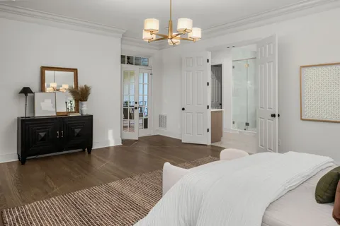 a spacious bedroom with a bed and a chandelier