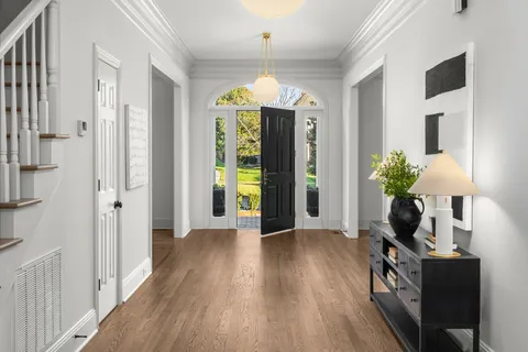a view of hallway with furniture and a chandelier