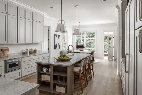 a view of a kitchen with kitchen island granite countertop a table and chairs in it