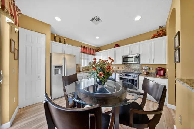 a kitchen with stainless steel appliances a dining table and chairs