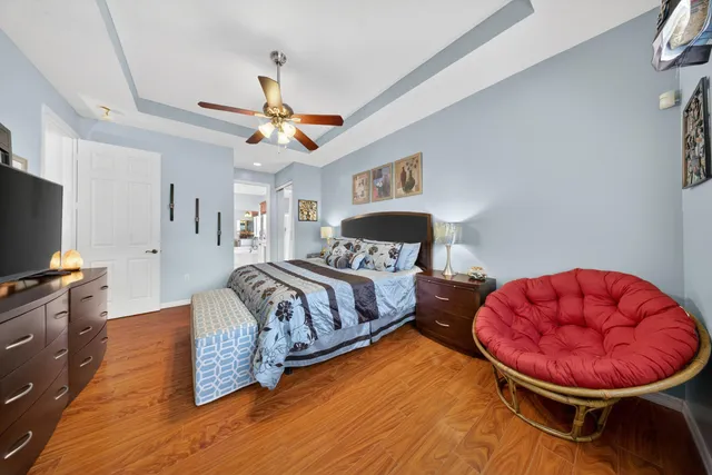 a spacious bedroom with a bed and wooden floor