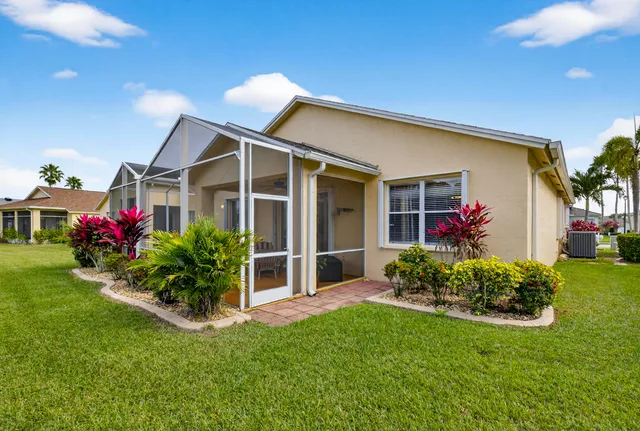 a view of a house with a big yard and potted plants