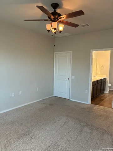 en empty room with windows and chandelier fan