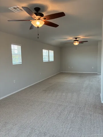 an empty room with a window and a fan