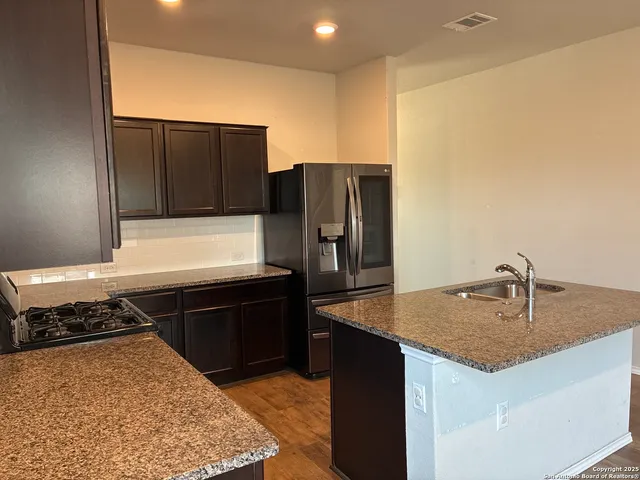 a kitchen with stainless steel appliances granite countertop a sink stove and refrigerator