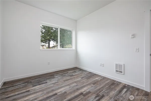wooden floor in an empty room with a window