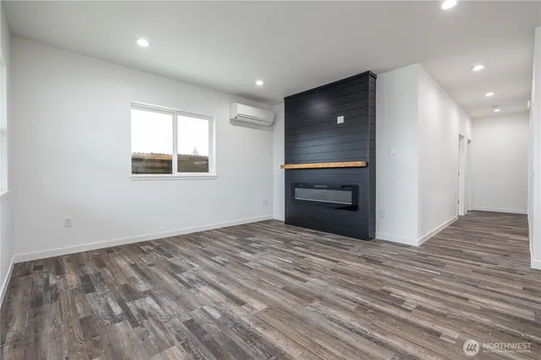 a view of an empty room with a kitchen and a window