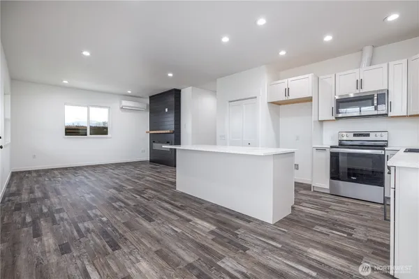 a kitchen with stainless steel appliances kitchen island granite countertop a stove a sink and a refrigerator