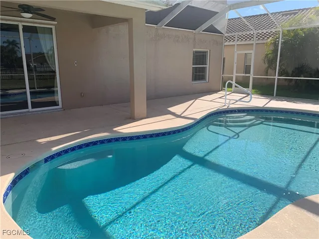 a view of an empty room with wooden floor and windows