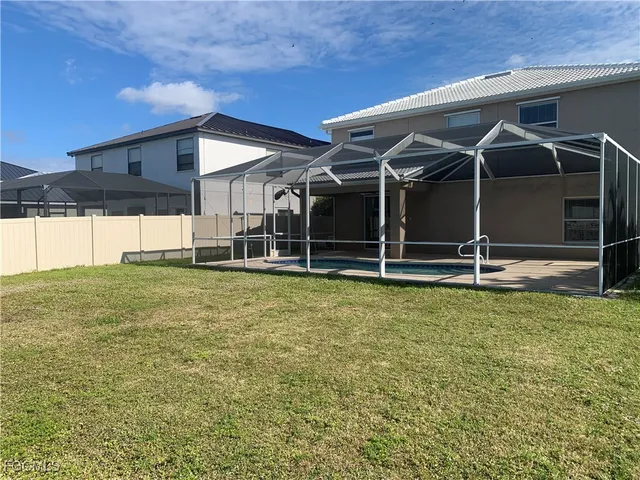 a view of a house with a yard and a large tree