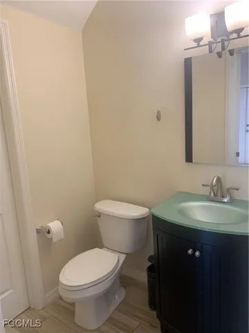 a bathroom with a toilet a sink and mirror