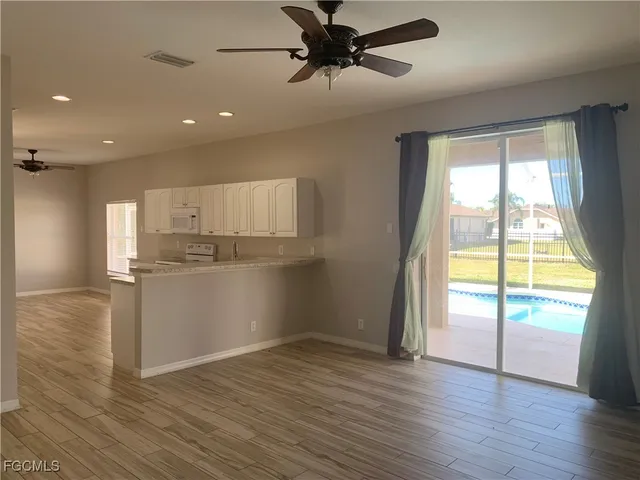 a view of a kitchen with a sink and wooden floor