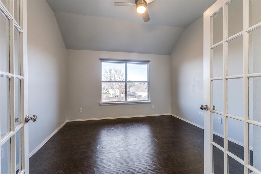Spare room featuring french doors, baseboards, ceiling fan, dark wood-style floors, and vaulted ceiling