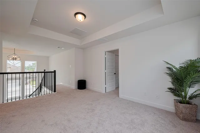 a spacious bedroom with a bed and a chandelier
