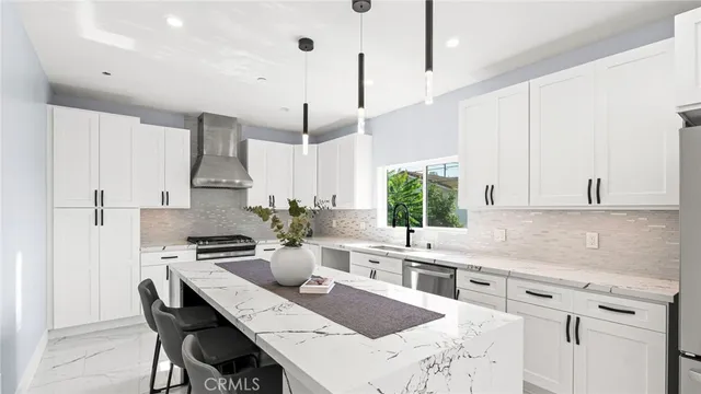 a kitchen with stainless steel appliances kitchen island granite countertop a sink a stove and a refrigerator