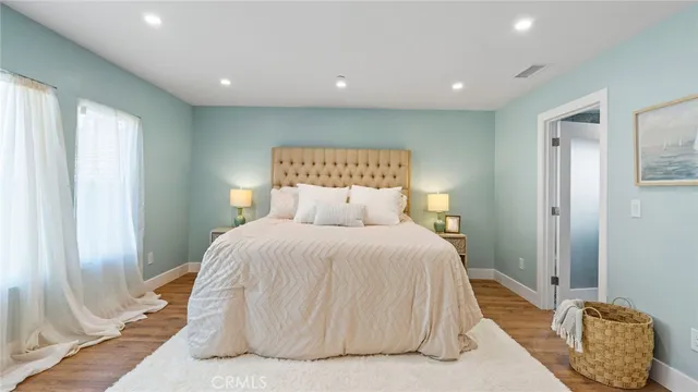 a spacious bedroom with a bed and a mirror