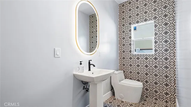 a bathroom with a toilet sink and mirror