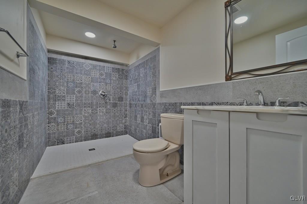 139 Winter Hill Road Effort, PA 18330 - Photo 44 of 50 a bathroom with a granite countertop sink a toilet and a mirror