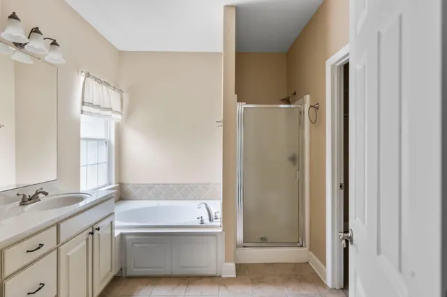 a bathroom with a tub sink and mirror
