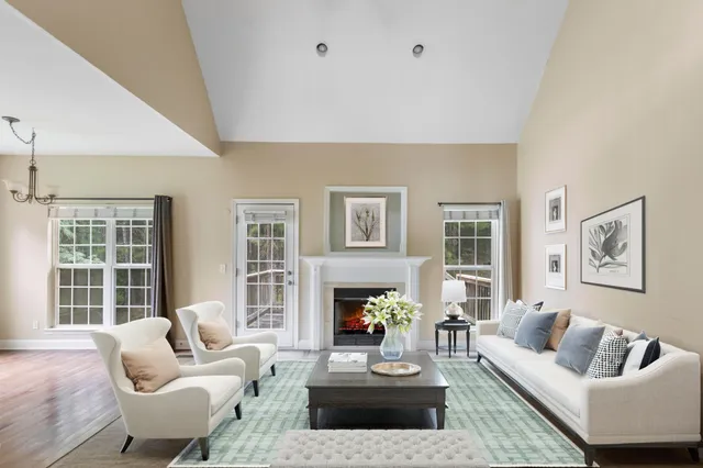 a living room with furniture a fireplace and a large window