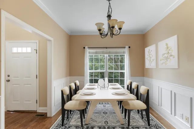 a view of a dining room with furniture a chandelier and wooden floor