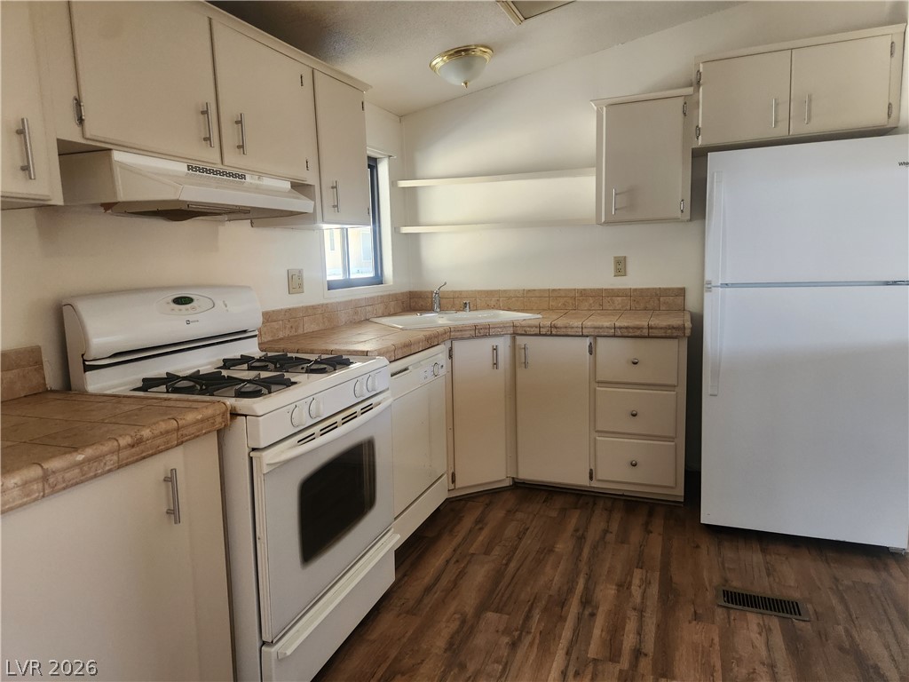 3189 Del Monte Street Laughlin, NV 89029 - Photo 8 of 32 A well-appointed kitchen features ample cabinetry, practical tile countertops, and durable wood flooring.