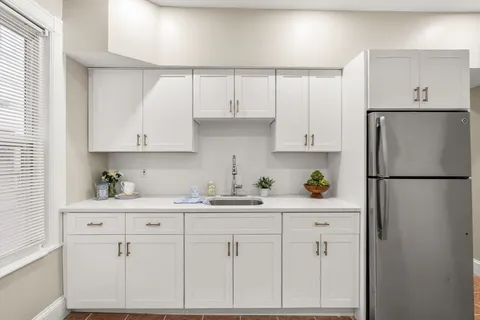 a kitchen with cabinets appliances a sink and a window