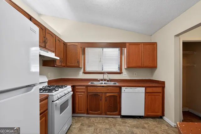 a kitchen with stainless steel appliances granite countertop a stove a sink and a microwave