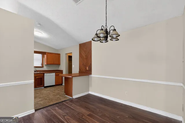 a kitchen with wooden floor and electronic appliances