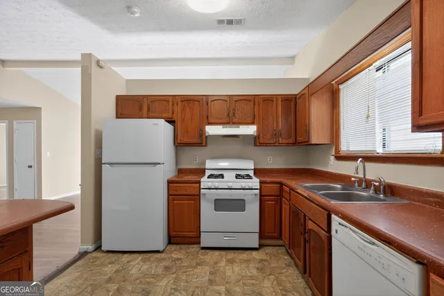 a kitchen with a sink stove and refrigerator