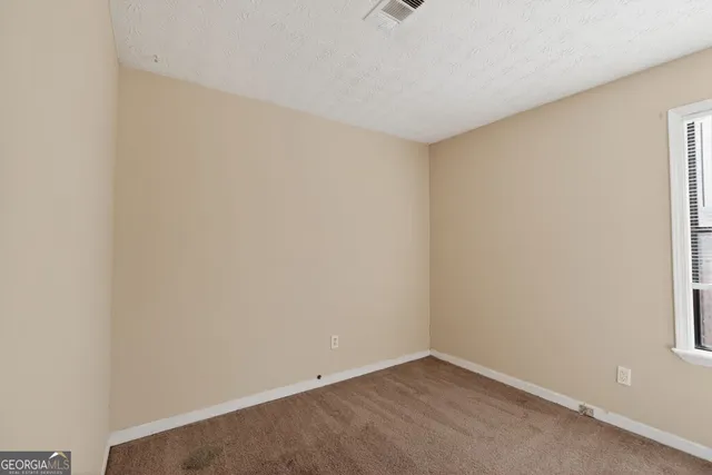 a view of an empty room and a window