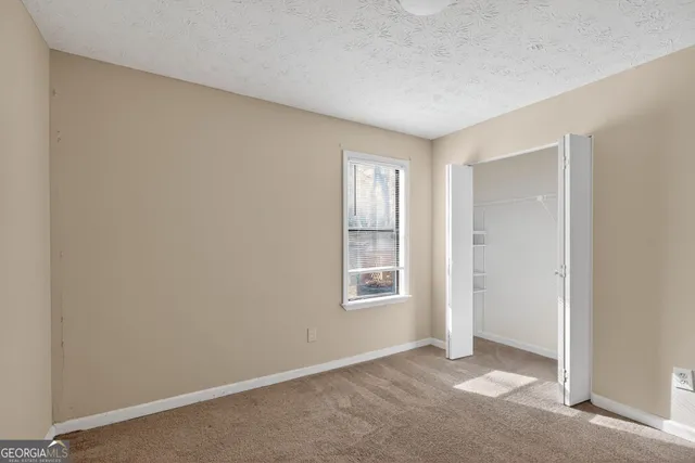 an empty room with windows and closet