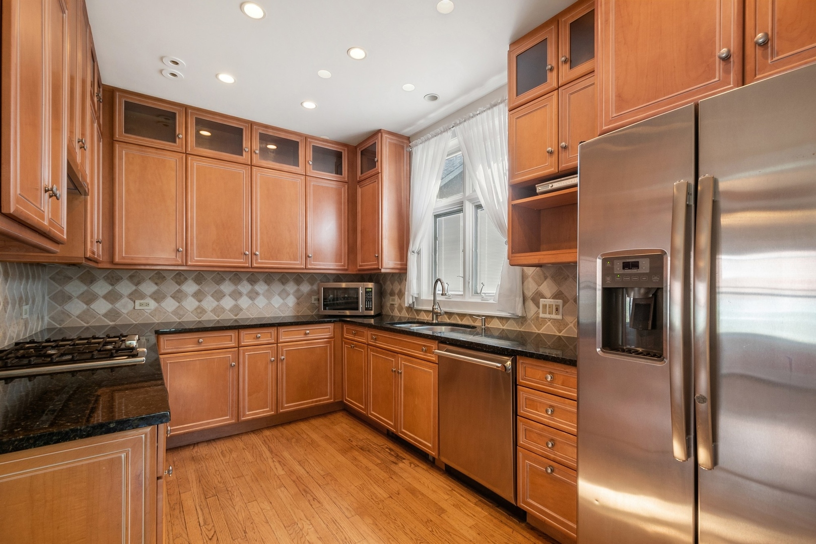 504 Maple Avenue Wilmette, IL 60091 - Photo 4 of 20 a kitchen with stainless steel appliances granite countertop a refrigerator a sink and white cabinets