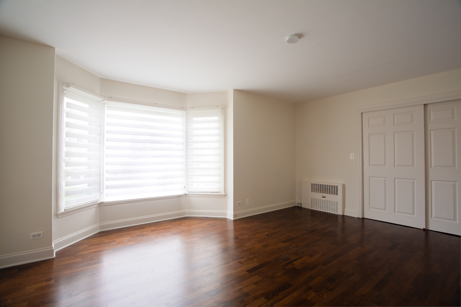 2400 Archbury Lane, Unit 1E Park Ridge, IL 60068 - Photo 15 of 18 an empty room with wooden floor and windows with curtains view