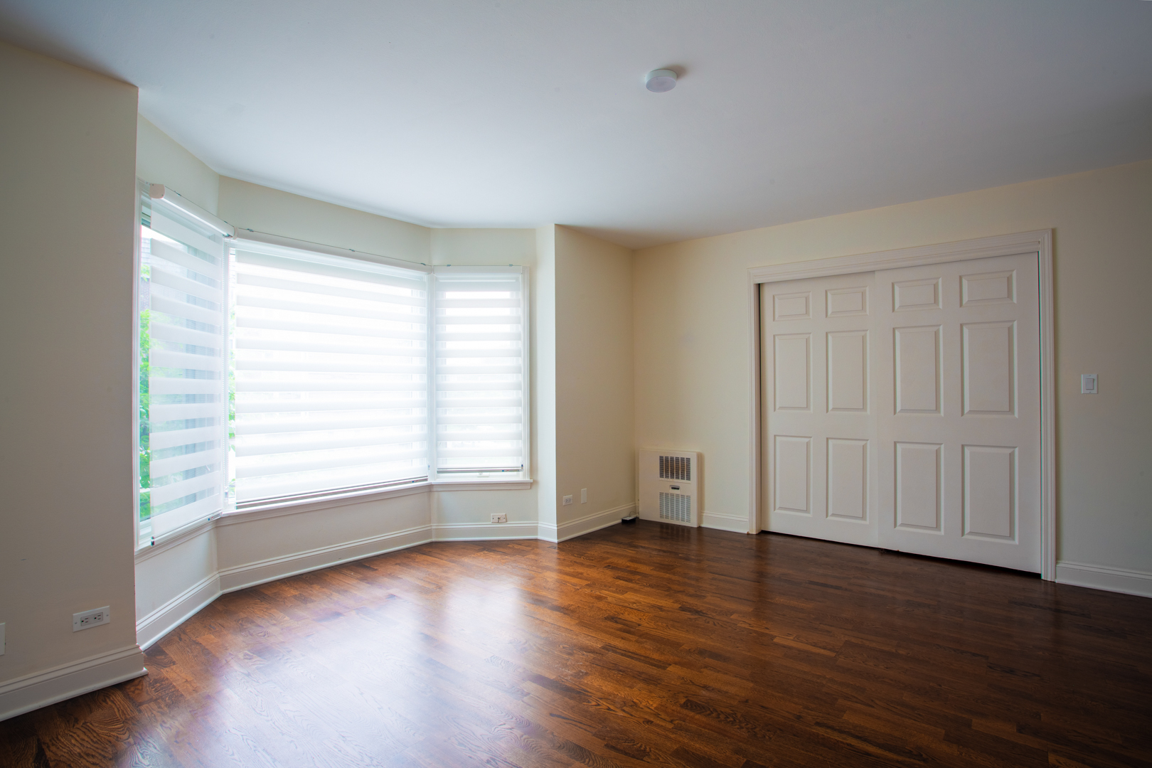 2400 Archbury Lane, Unit 1E Park Ridge, IL 60068 - Photo 16 of 18 an empty room with wooden floor and windows with curtains view