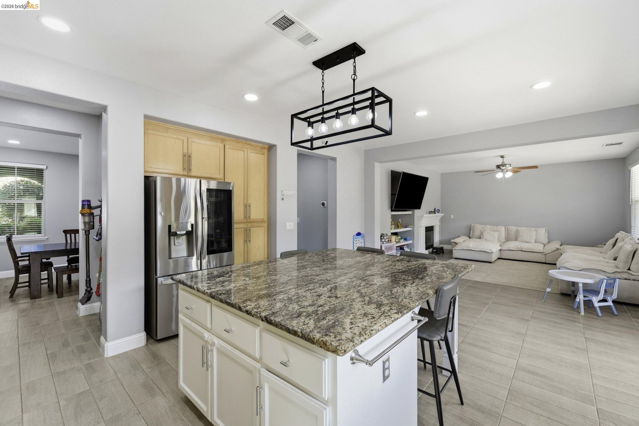 4568 Le Conte Circle Antioch, CA 94531 - Photo 35 of 36 Kitchen with open floor plan, stainless steel fridge with ice dispenser, a breakfast bar area, ceiling fan, and dark stone counters