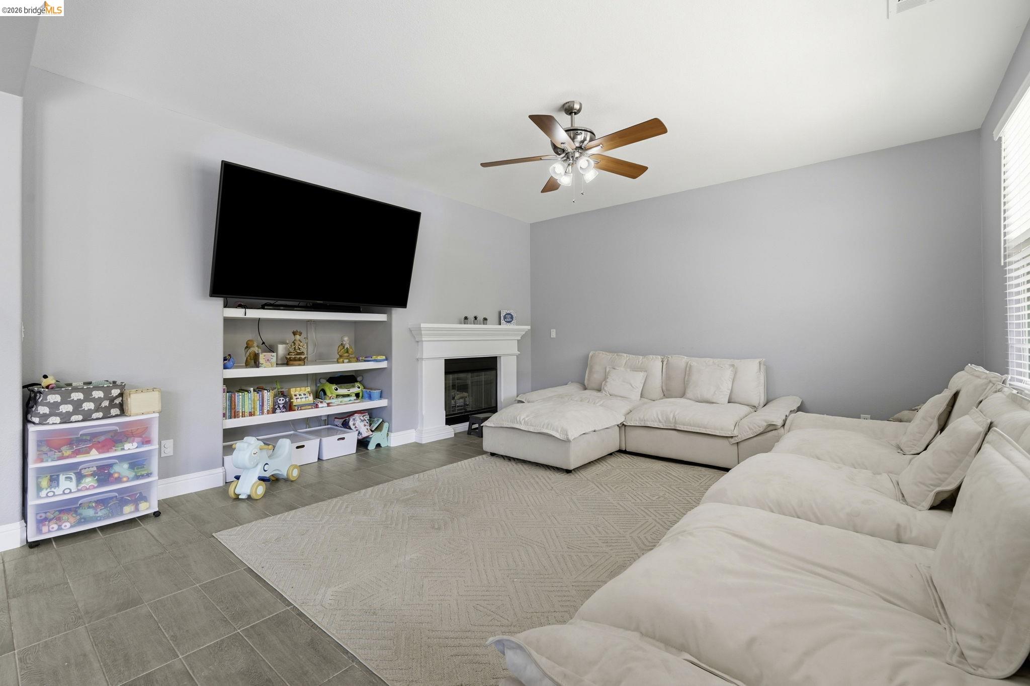 4568 Le Conte Circle Antioch, CA 94531 - Photo 28 of 36 Living room featuring a ceiling fan and a glass covered fireplace