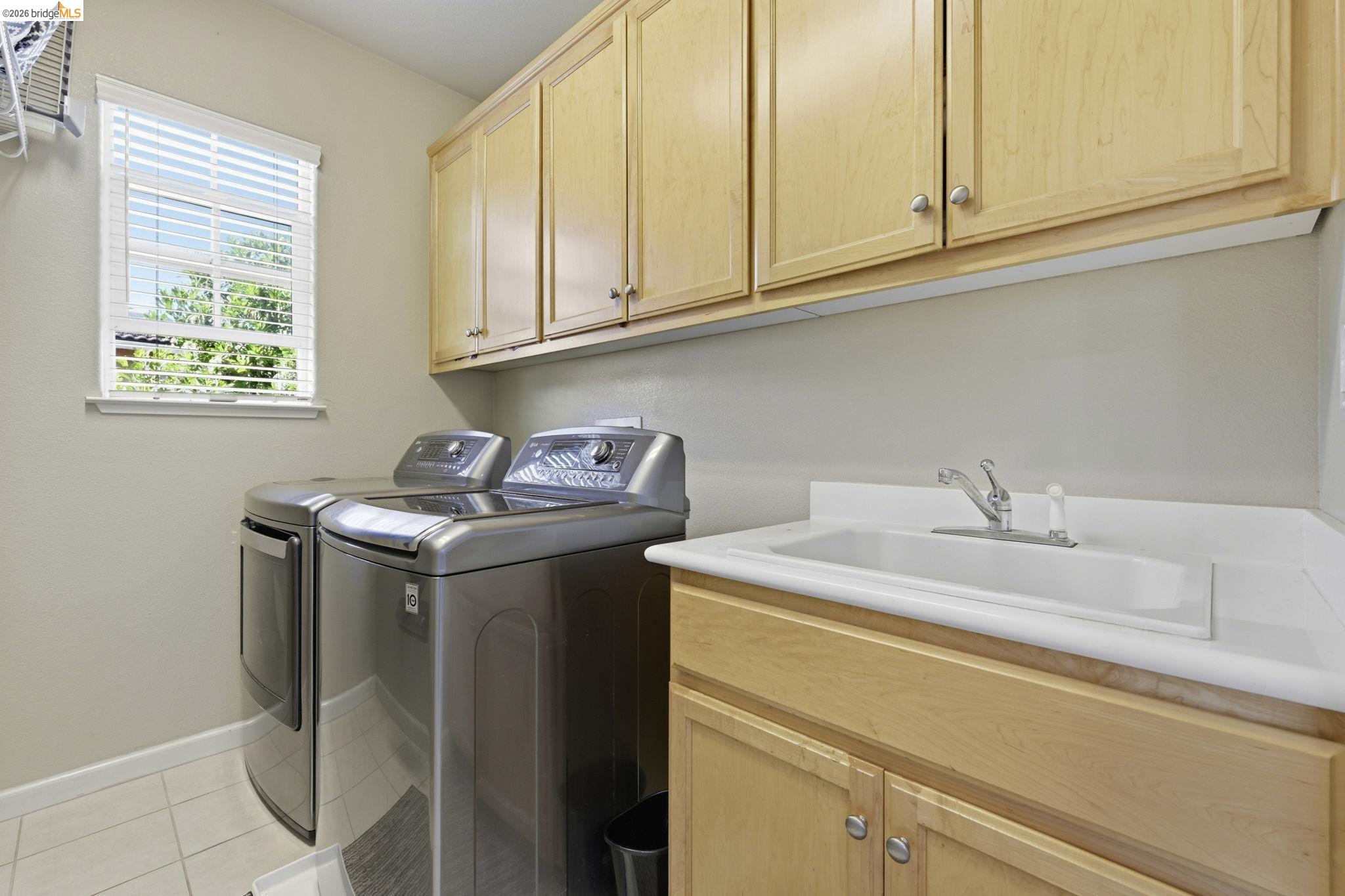 4568 Le Conte Circle Antioch, CA 94531 - Photo 32 of 36 Upstairs Laundry area featuring washer and dryer, cabinet space, and light tile patterned flooring