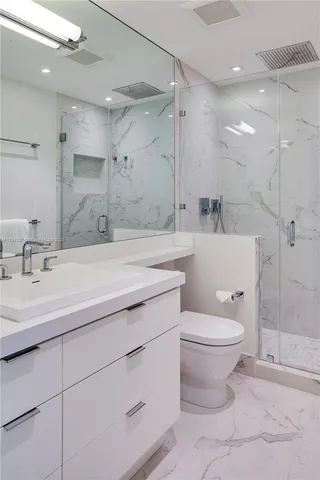 a bathroom with a sink a toilet and shower