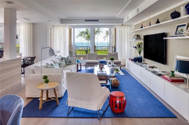 a living room with furniture a flat screen tv and a large window