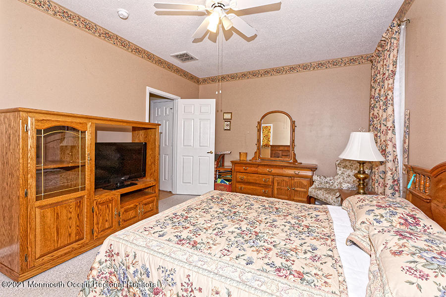 54 Quail Road Barnegat, NJ 08005 - Photo 22 of 24 a bedroom with a bed and a flat tv screen on dresser