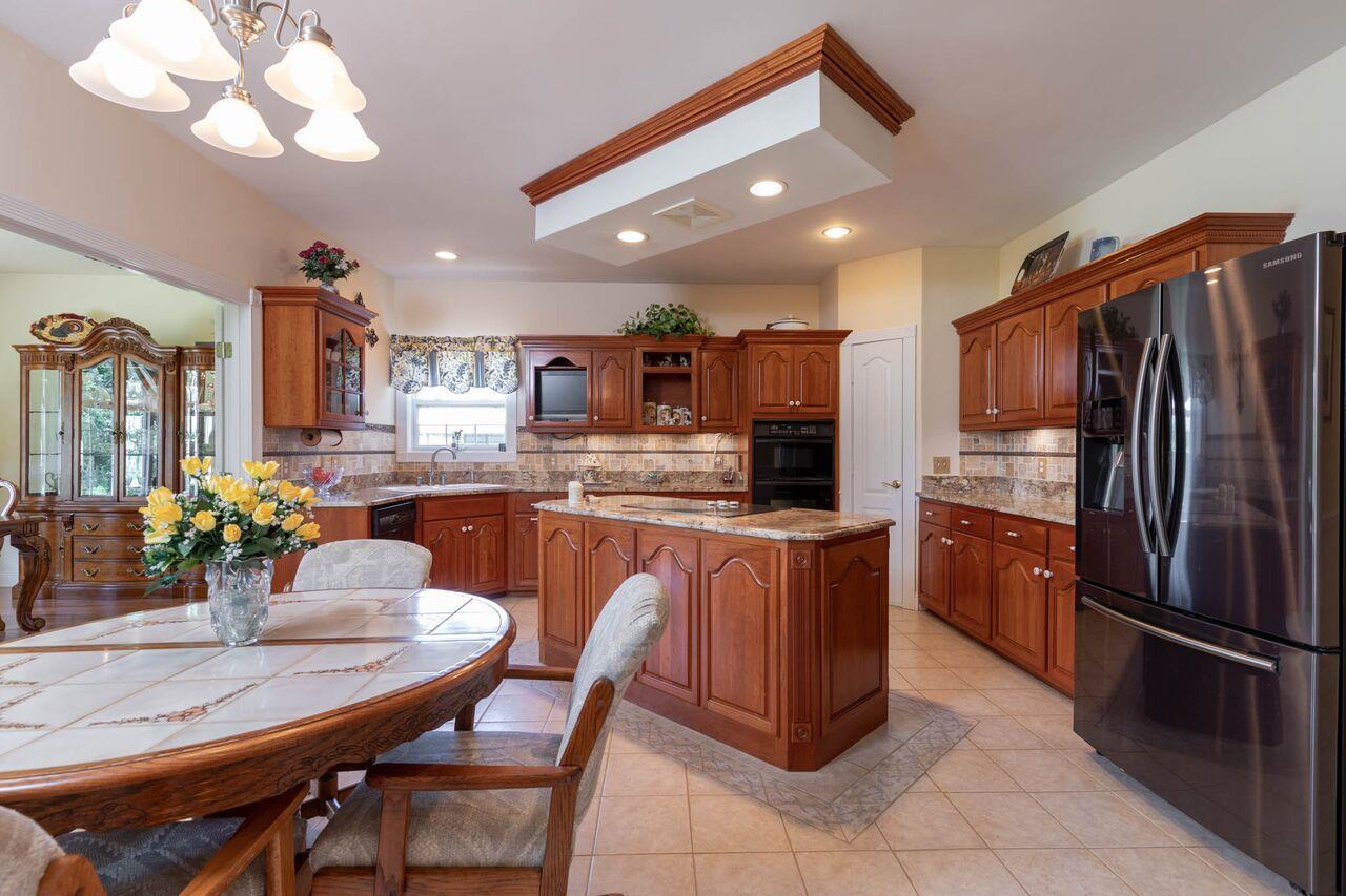 365 Normandy Road Wartrace, TN 37183 - Photo 6 of 30 a kitchen with stainless steel appliances granite countertop a refrigerator a sink a stove a dining table and chairs