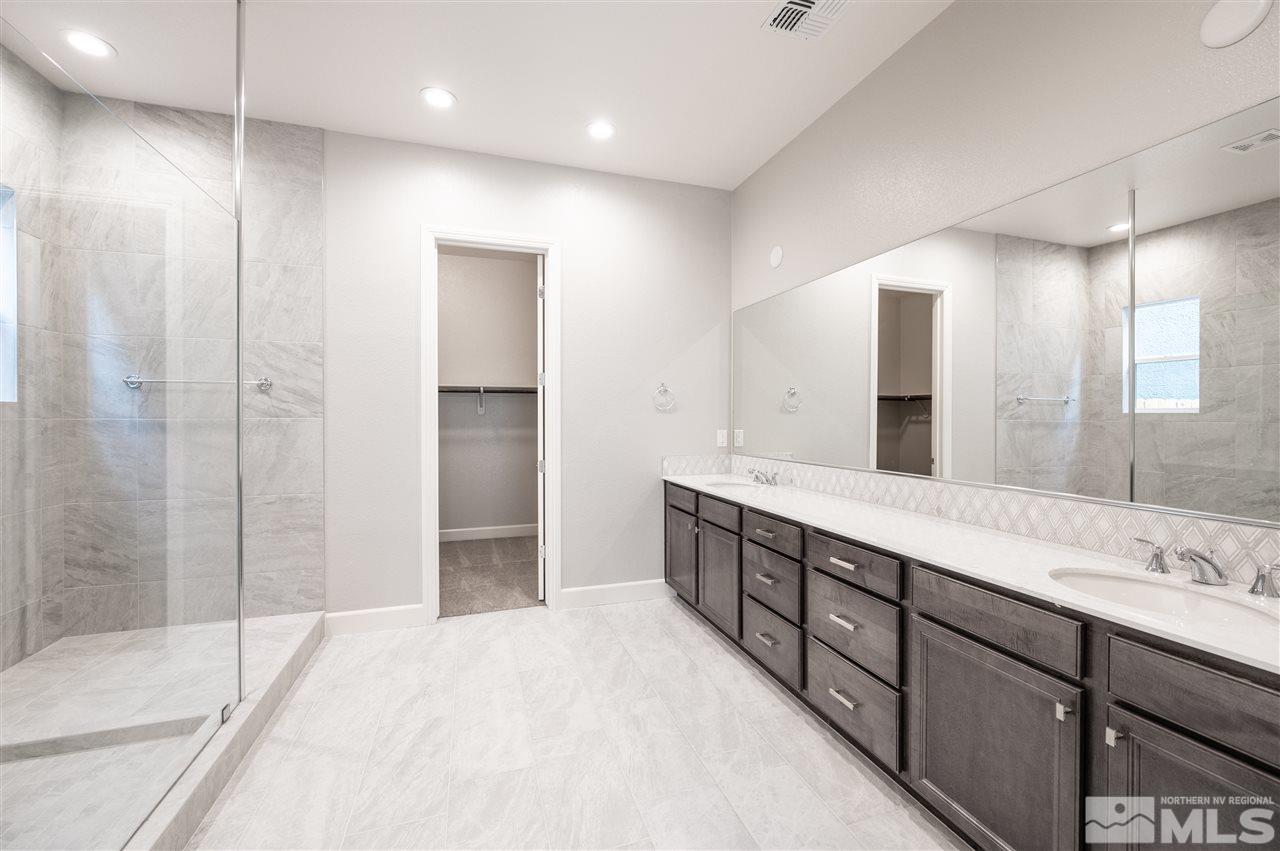 9425 Hawkshead Road, Unit HOMESITE 93 Reno, NV 89521 - Photo 10 of 11 a spacious bathroom with a double vanity sink mirror and shower